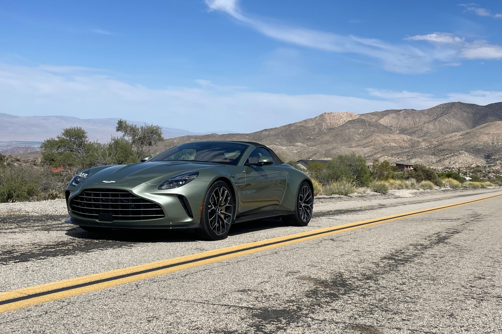 Light green metallic 2026 Aston Martin Vantage Roadster viewed from the front quarter with the top up